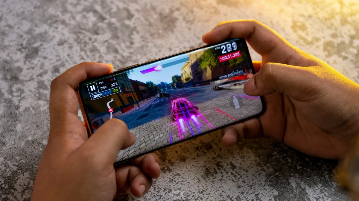 A person holding a smartphone with a video game on the screen.